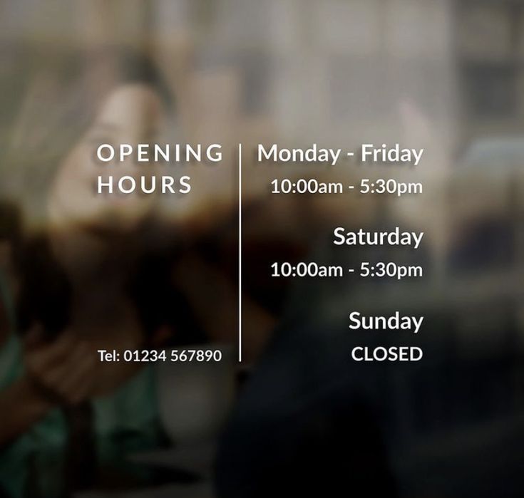 an open hours sign with people in the background