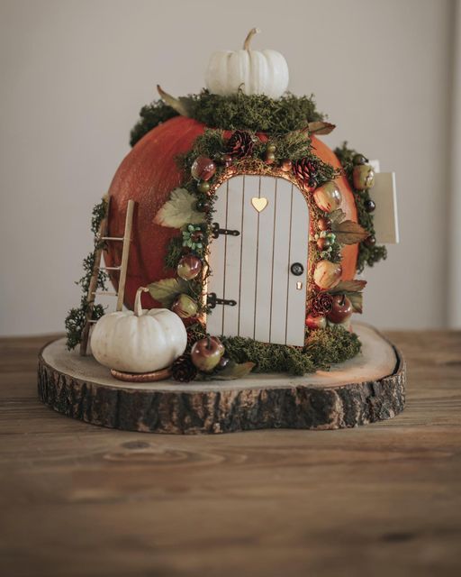 a wooden table topped with a fake door and pumpkins