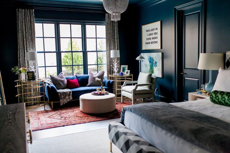 a bedroom with blue walls and furniture in the corner, along with a chandelier hanging from the ceiling