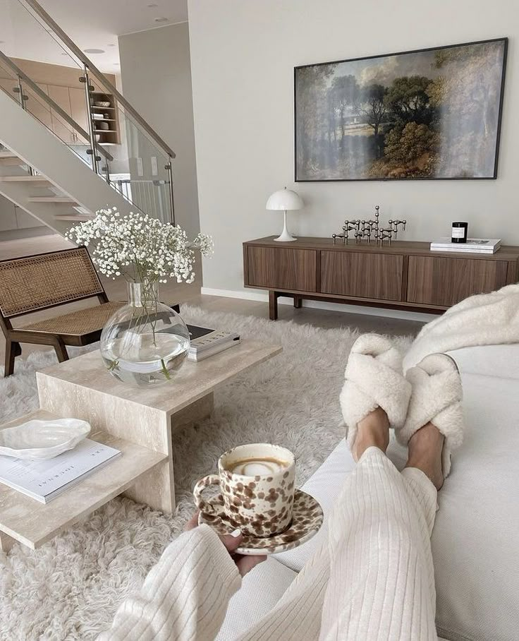 a person sitting on the floor with their feet up in front of a coffee table