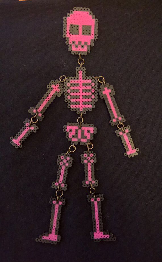 a pink pixelated skeleton keychain on a black background with the word,