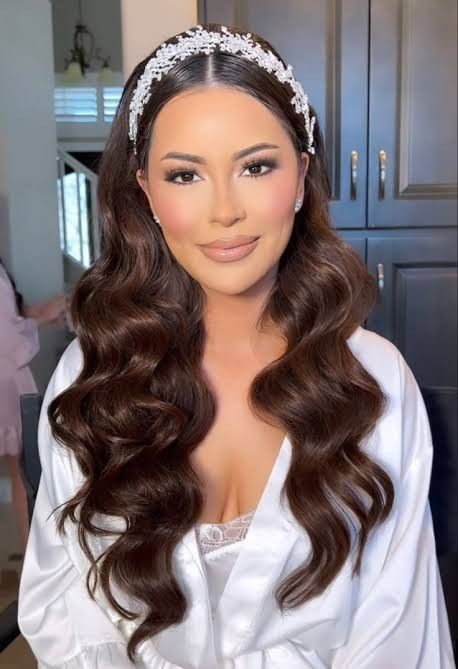 a woman with long brown hair wearing a white dress and tiara on her head