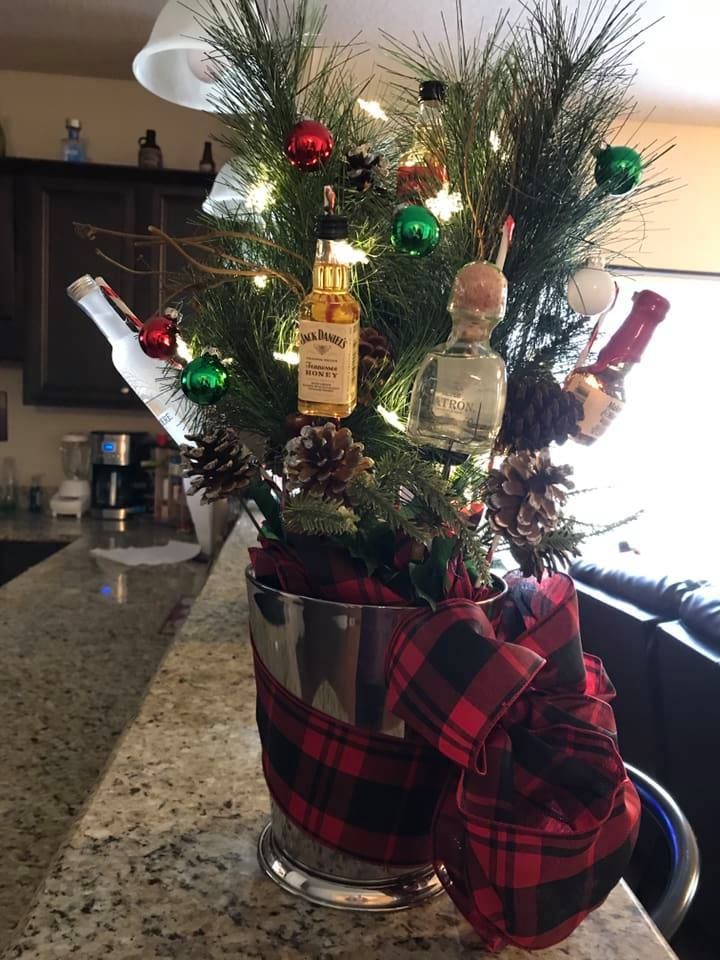 a christmas tree in a bucket with liquor bottles