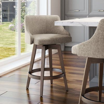 two stools sit in front of a kitchen counter with an island and large windows