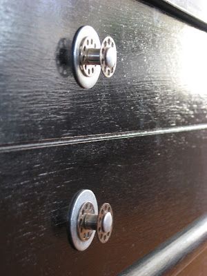 two knobs on the side of a black dresser