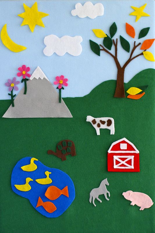 paper cut outs depicting farm animals and trees on a green field with blue sky in the background