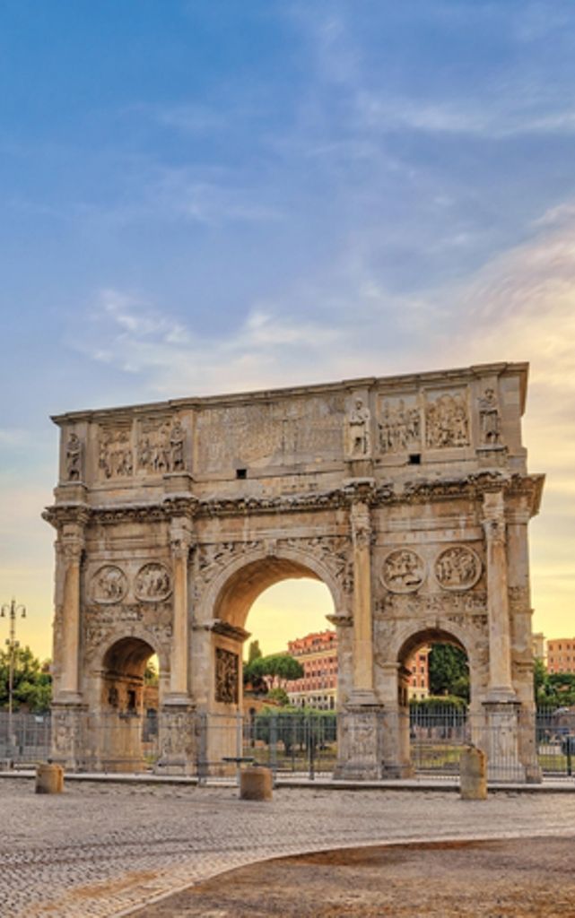 an arch of triumph in the middle of a square with people walking around it at sunset