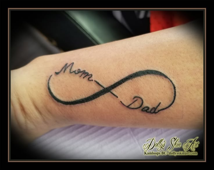 a tattoo with the word mom and an infinite knot on it's arm, in black ink