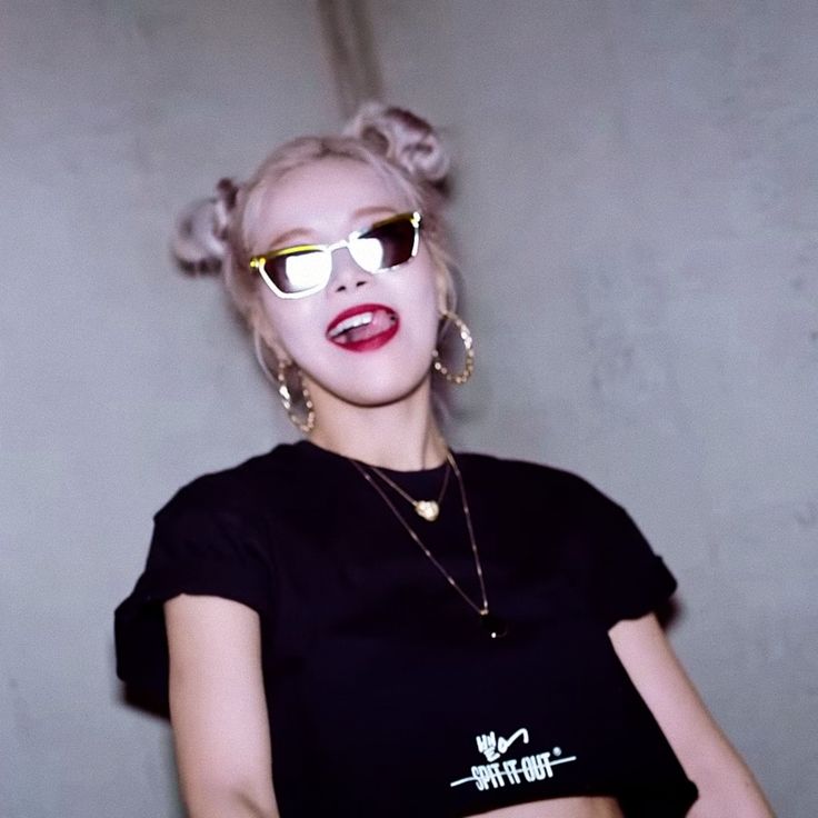 a woman with blonde hair wearing sunglasses and a black shirt is posing for the camera