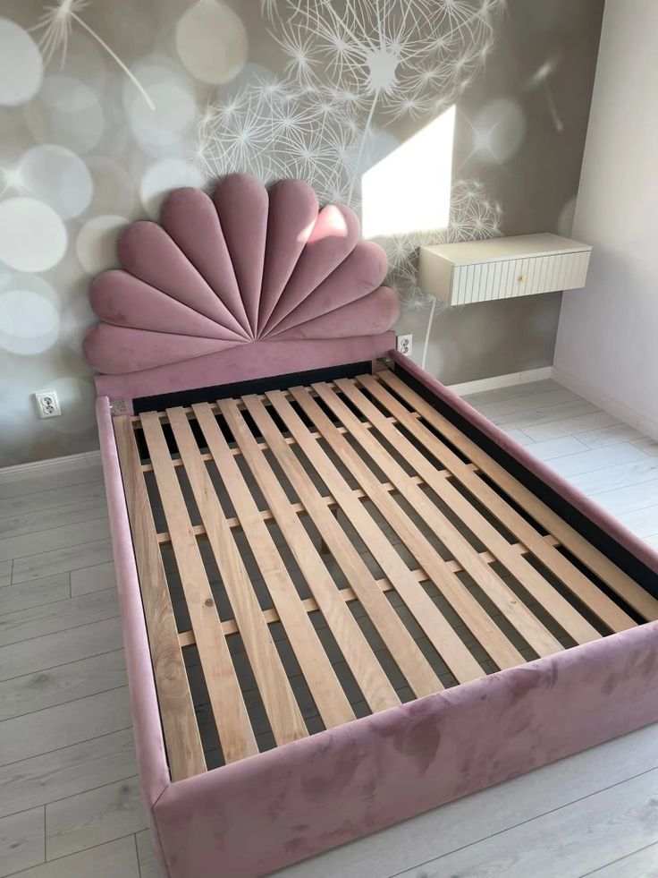 a pink bed with an intricate headboard and foot board