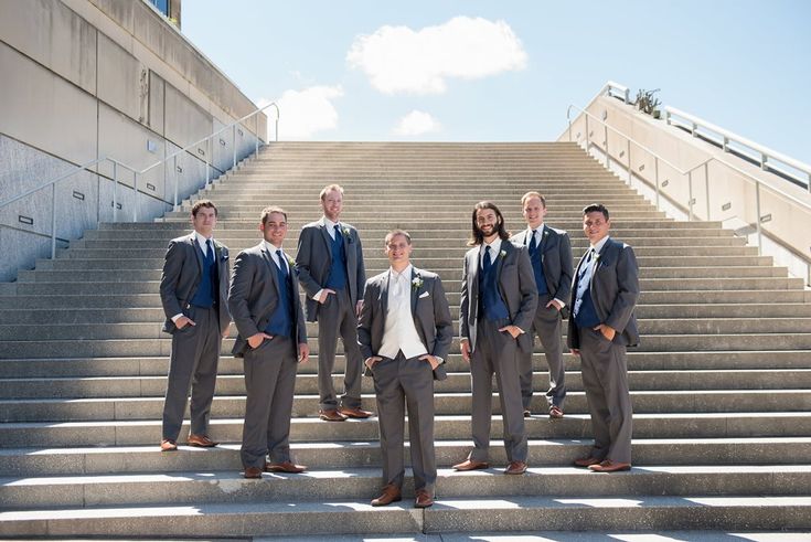 a group of men in suits standing on some steps with their hands in their pockets