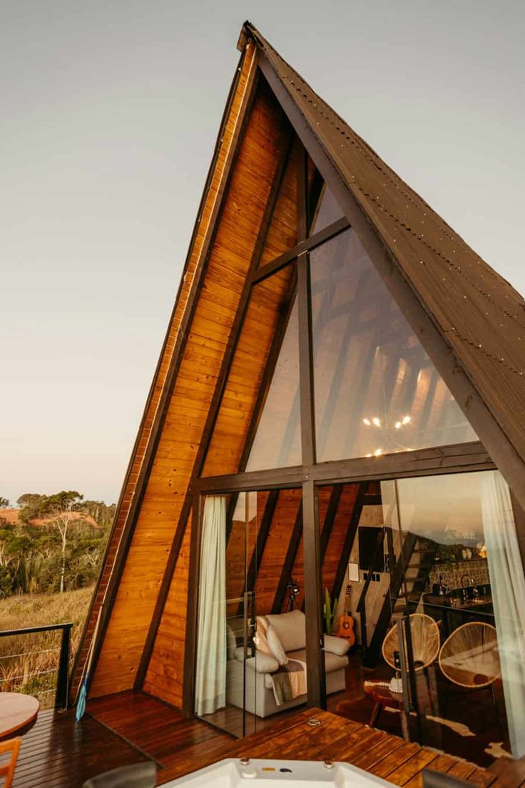 a wooden house with a hot tub in front of it and an open patio area