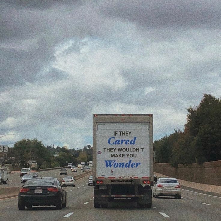 a large truck driving down a highway under a cloudy sky