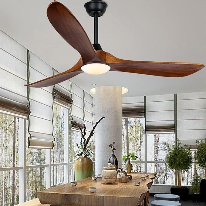 a ceiling fan is hanging in the middle of a room with large windows and wooden tables