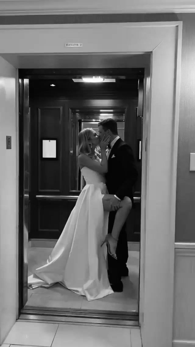 the bride and groom are kissing in front of an elevator door at their wedding reception