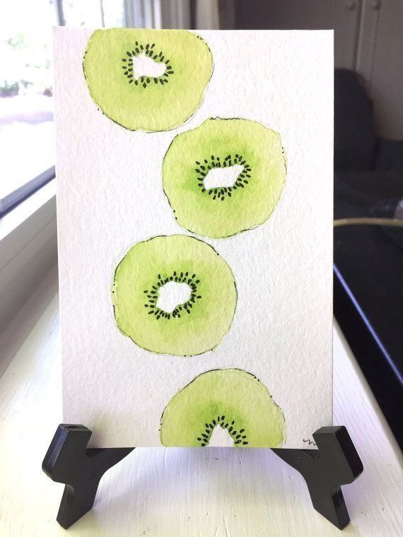 a card with three kiwis on it sitting on a table next to a window