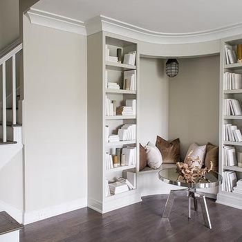 a living room filled with furniture and bookshelves next to a wall mounted book shelf