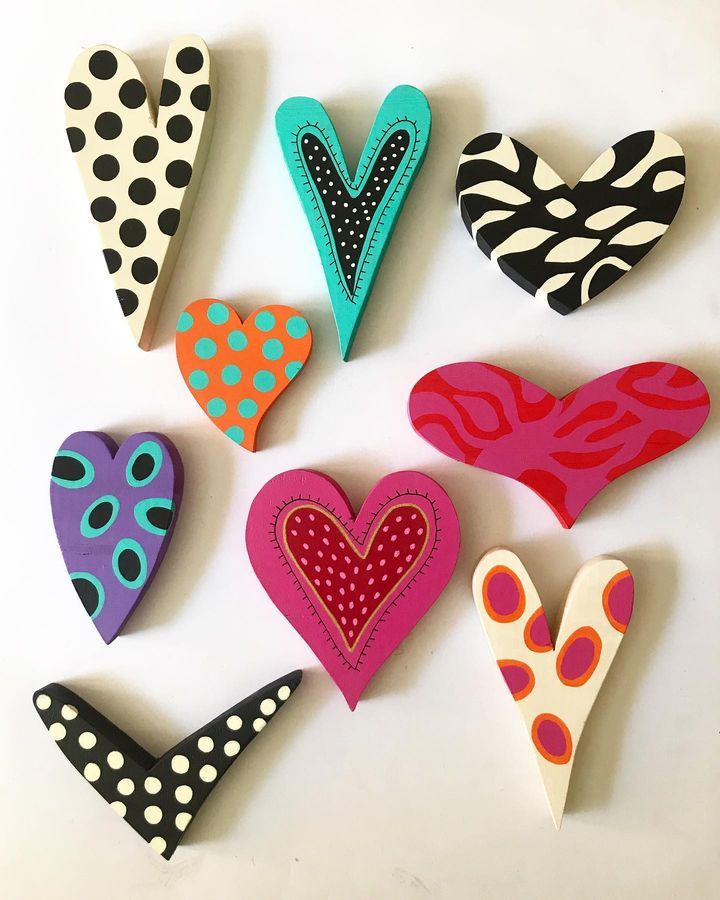 several different types of heart shaped brooches on a white surface with polka dots