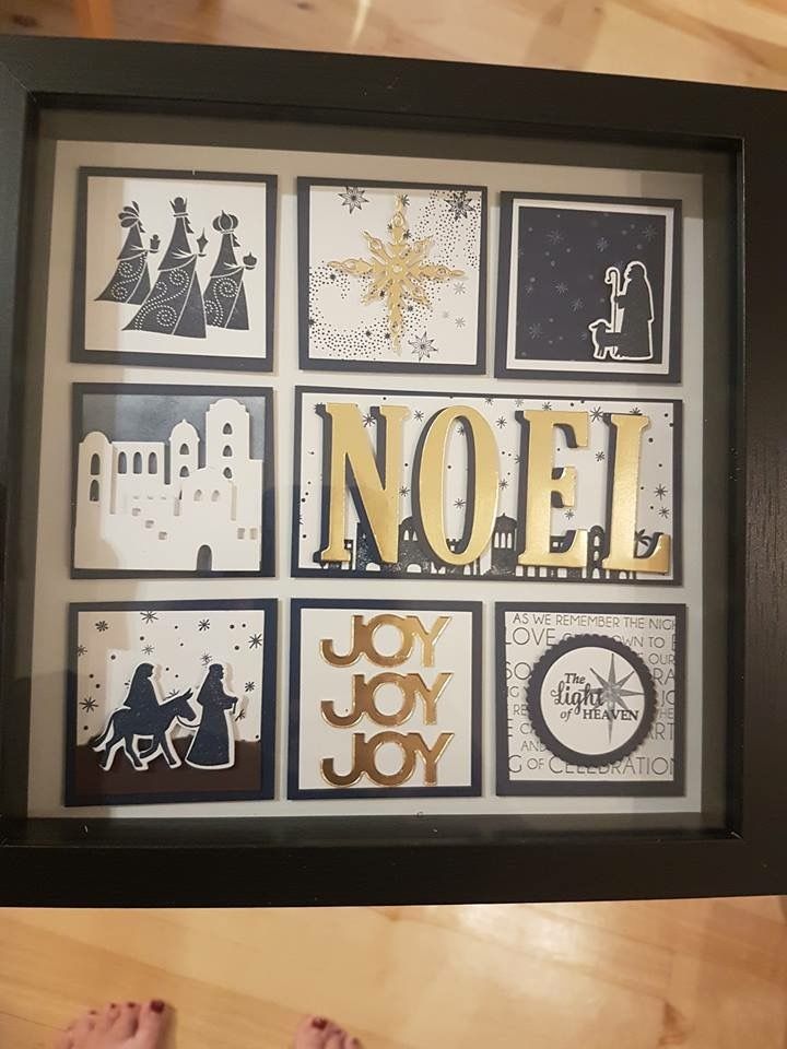 a person's feet are standing in front of a framed art piece that says noel