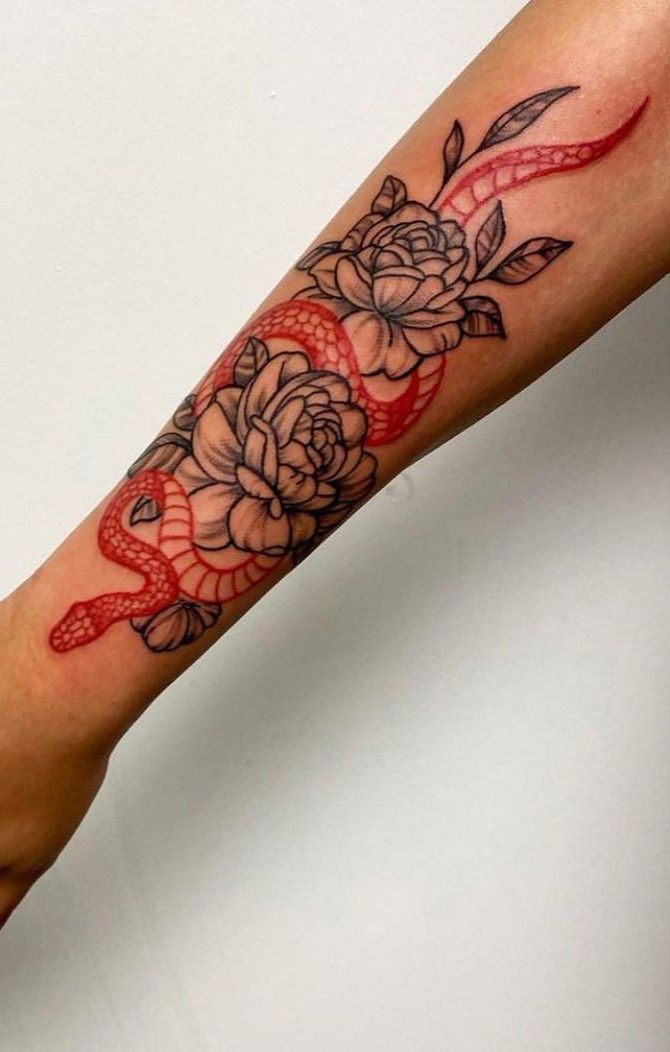 a woman's arm with a rose and snake tattoo on the left side of her arm