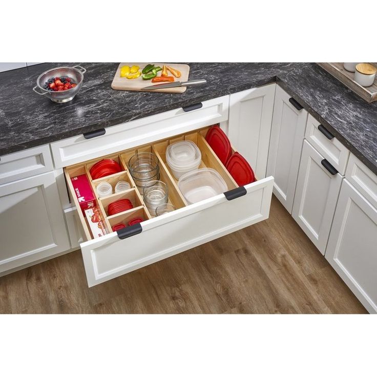 an open drawer in the middle of a kitchen