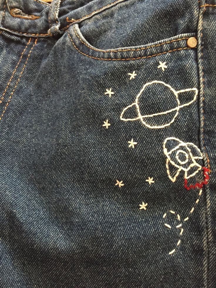 the back pocket of a pair of jeans with an embroidered rocket ship and stars on it