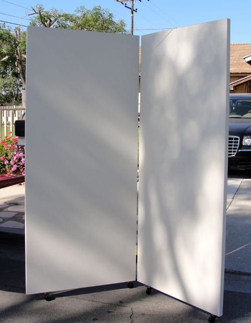 an open white door sitting on the side of a road next to a parking lot