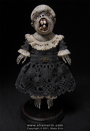 a creepy doll is standing on a black surface with its mouth open and tongue out