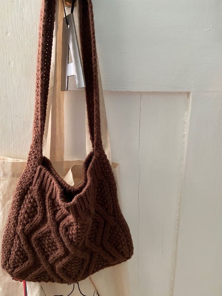 a brown purse hanging from a hook on a wall