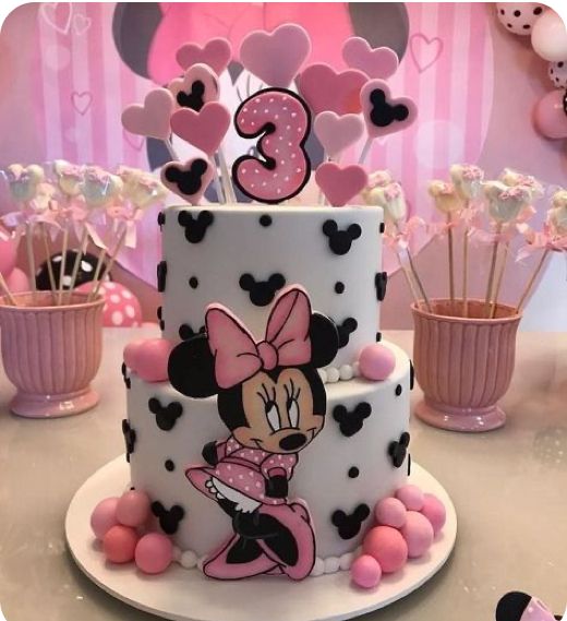 a minnie mouse birthday cake with pink and black decorations