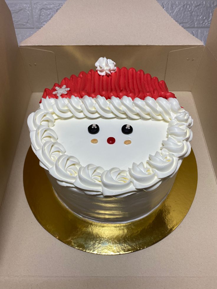 a cake in the shape of a santa claus head with red and white frosting