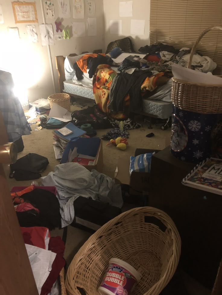 a messy bedroom with clothes and other items on the floor