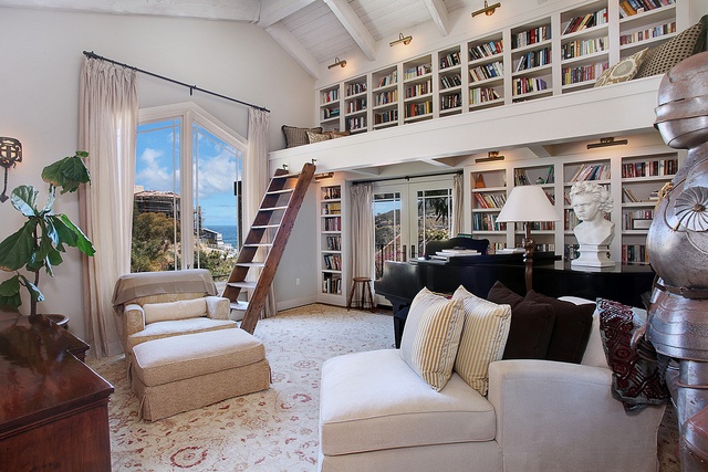 a living room filled with lots of furniture and bookshelves next to a window