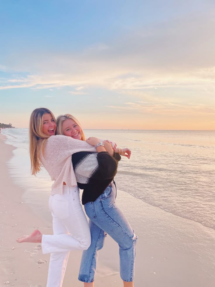 two women on the beach hugging each other