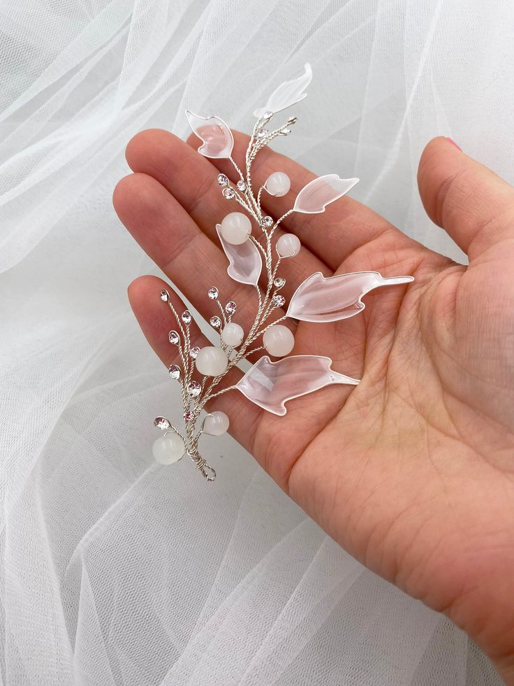 Bridal hair piece with acrylic leaves for a wedding hairstyle. White acrylic leaves with a transparent middle on the thinnest branches of the bridal hair vine for a wedding hairstyle. Silver rhinestones add extra elegance to the hair accessory. White glass beads complete the beauty of the hair accessory.The bridal vine for a wedding hairstyle harmonizes with any white dress. The hair vine is most successfully combined with dresses containing elements of similar colors. It will adorn both blonde Acrylic Leaves, Flowy Hair, Leaf Hair Piece, Pearl Hair Piece, Brunette Makeup, Beautiful Tiaras, Bridal Hair Piece, Flower Gift Ideas, Bride Hair Accessories