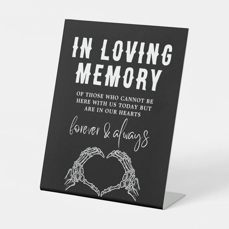 a card with the words in loving memory and two hands holding each other's heart