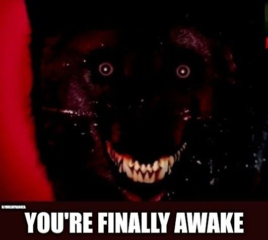 a black dog with its mouth open and fangs on it's face that says, you're finally awake