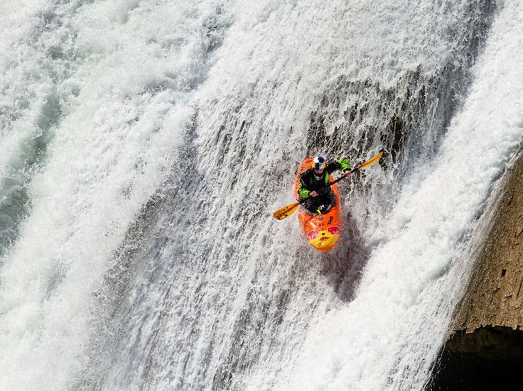 a man is kayaking down the side of a waterfall