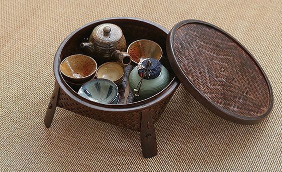 a small wooden box filled with different types of teacups on top of a rug