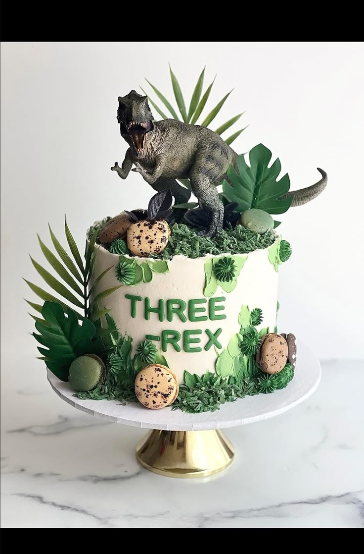 there is a cake decorated to look like a t - rex on top of the cake