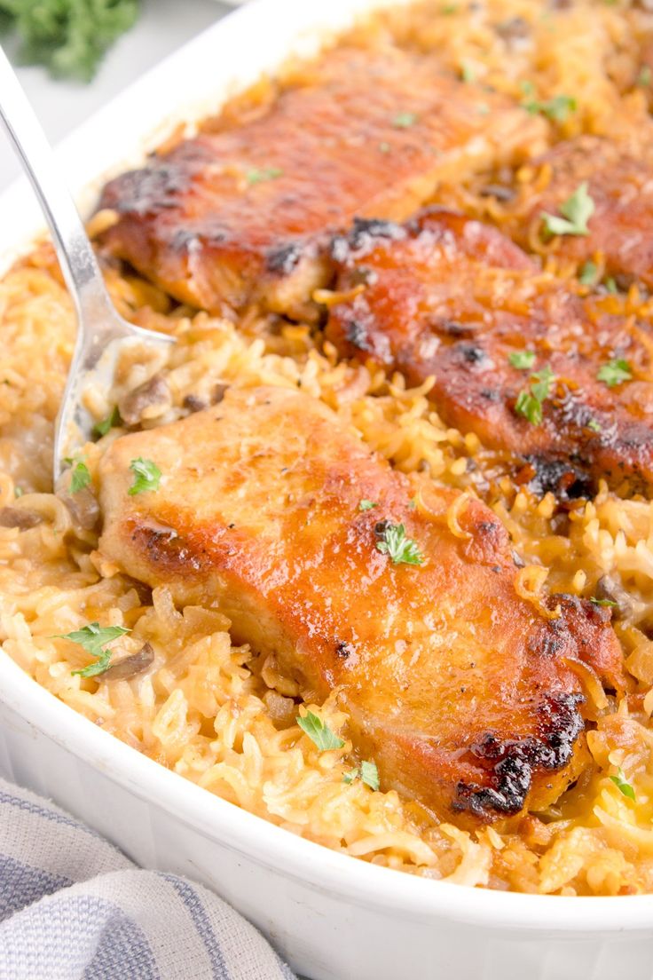 chicken and rice casserole in a white dish with a serving spoon resting on top