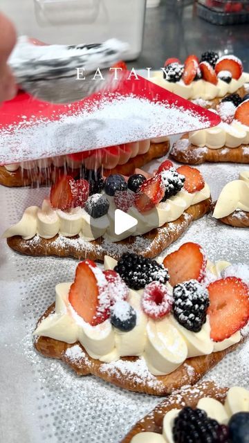 several pastries are covered with fruit and powdered sugar