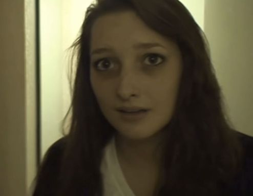 a woman with long brown hair is looking at the camera and she has an intense look on her face