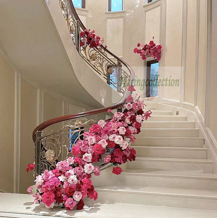 pink and white flowers are on the handrail of a stair case in a home