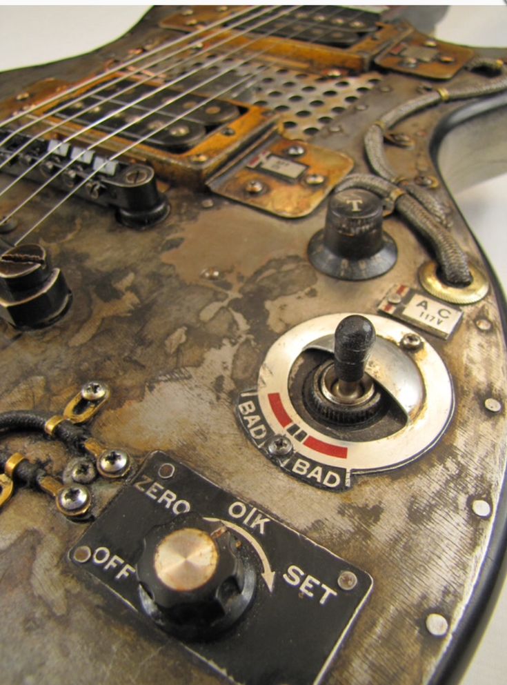 an old, dirty electric guitar with some knobs and wires attached to it's body