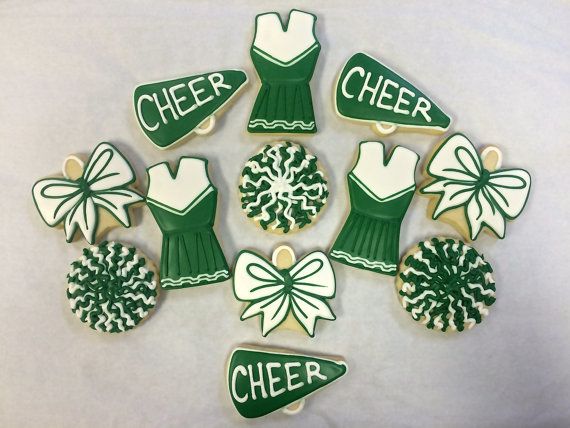 green and white decorated cookies arranged in the shape of cheerleaders