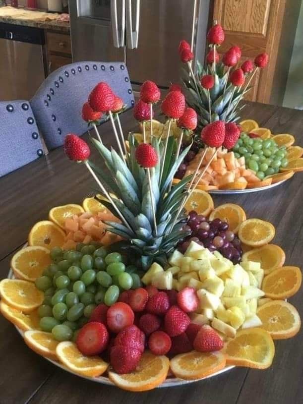 fruit platter with pineapples, oranges, grapes and strawberries on it