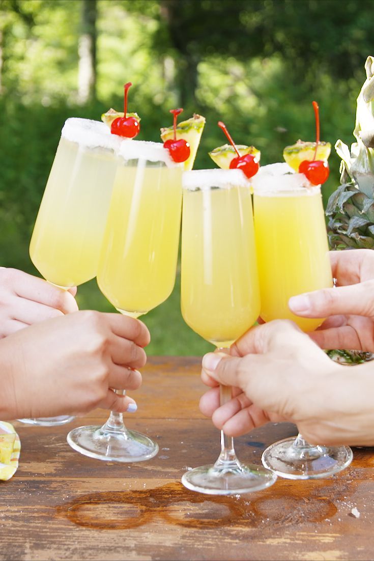 four people toasting with glasses of lemonade and cherries on the rims