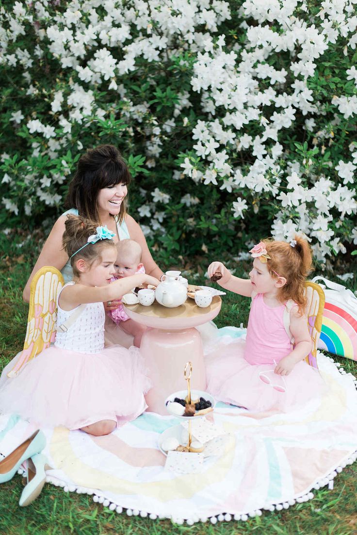 a group of women sitting around a table with cupcakes on it