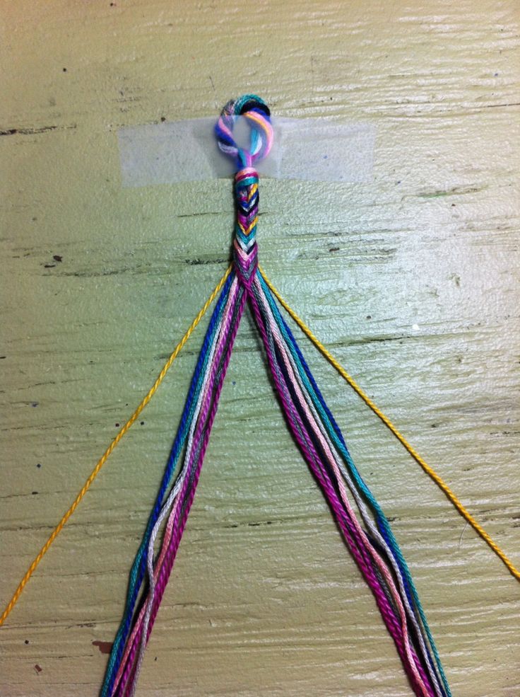 a colorful piece of string hanging from a wooden wall